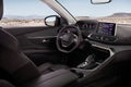 Cockpit of a modern SUV with a view of the desert and mountains.