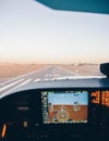 Cockpit of a small plane landing on the airport runway at sunset Royalty Free Stock Photo