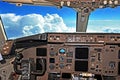 Cockpit view cruising at high altitude past a large thunderstorm. Shoowing the captain\'s instruments and controls of the Boeing