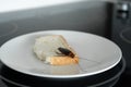 A cockroach is sitting on a piece of bread in a plate in the kitchen. Cockroaches eat my food supplies