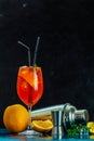 Cocktail aperol spritz in big wine glass with water drops on dark background