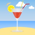 Cocktail on the beach. A glass of cocktail with an lemon slice on the sand against the background of the sea and sky. The concept