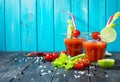 Cocktail Bloody Mary with ice in glasses on a wooden table