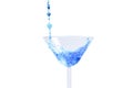 Cocktail with blue liquid in glass. Glass with blue water pouring with liquid with splashes and drops. Martini glass filling with Royalty Free Stock Photo