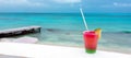 Cocktail with caribbean sea on background. Concept of beautiful tropical vacation Royalty Free Stock Photo