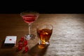 Cocktail and cognac near deck of cards and dice on wooden surface isolated on black Royalty Free Stock Photo