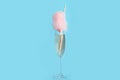 Cocktail with cotton candy in glass on blue background Royalty Free Stock Photo