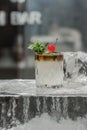 Cocktail decorated with cherries and mint stands on a piece of ice Royalty Free Stock Photo