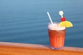 Cocktail with fruits in glass on ship deck rail Royalty Free Stock Photo