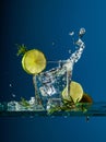 Cocktail gin-tonic with lime and rosemary on a glass table