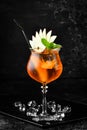 Cocktail in a glass - Aperol spritz. on a black stone background. Menu bar. Alcohol