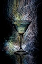 Cocktail glass on a black background with light painting streaks. Royalty Free Stock Photo