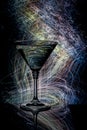 Cocktail glass on a black background with light painting streaks.