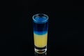 Alcohol bar, cocktail glass on black background, shot cocktail blue yellow color Royalty Free Stock Photo