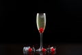 Cocktail glass with cold champagne, ripe red cherries and ice cubes isolated on black background. Royalty Free Stock Photo