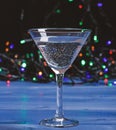 Cocktail glass on defocused garland colorful lights. Alcohol cocktail for winter party. Cocktail ideas concept. Easy Royalty Free Stock Photo