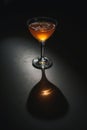 Cocktail Glass Shadow Ã¢â¬\' Dramatic Low-Angle Light Casting Sharp Shadow on Dark Surface Royalty Free Stock Photo
