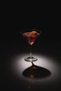 Cocktail Glass Shadow Ã¢â¬\' Dramatic Low-Angle Light Casting Sharp Shadow on Dark Surface Royalty Free Stock Photo