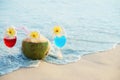 Cocktail glasses with coconut and pineapple on clean sand beach Royalty Free Stock Photo