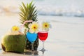 Cocktail glasses with coconut and pineapple on clean sand beach Royalty Free Stock Photo