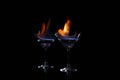 Cocktail glasses with flaming vodka on black background