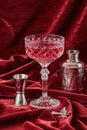 Cocktail with ice in a martini glass and bartender tools on a red velvet background Royalty Free Stock Photo