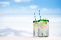 Cocktail with ice, rum, lemon and mint in a glass on beach Royalty Free Stock Photo