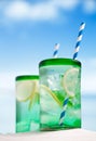 Cocktail with ice, rum, lemon and mint in a glass on beach Royalty Free Stock Photo