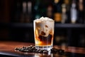 Cocktail layered baileys irish cream iced coffee on bar counter in a restaurant, pub. Drink with liqueur. Fresh prepared alcoholic