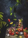 Cocktail with lime, crushed ice, strawberries and mint with fly ingredients on the dark background Royalty Free Stock Photo