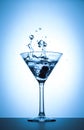 Cocktail martini glass splash on white and blue gradient background Royalty Free Stock Photo