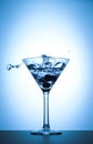 Cocktail martini glass splash on white and blue gradient background Royalty Free Stock Photo