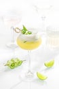 Cocktail mix in glass on white background with alcohol, cucumber, lemon and lime, cetriolo