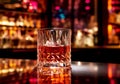 Cocktail Negroni with ice and orange peel in tall vintage retro crystal cut glass at the bar.