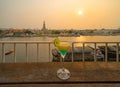 Cocktail punch drink glass on table in restaurant on balcony sky bar with Temple of Dawn and river, Bangkok city, Thailand skyline