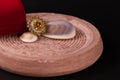 Cocktail ring with seashell and red gift box on sand stone on black background Royalty Free Stock Photo