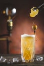 Cocktail on rustic wood background. Cold citrus alcohol beverage with tequila, blood juice and ginger beer, served with citrons Royalty Free Stock Photo