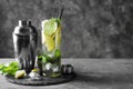 Cocktail shaker and glass of fresh mojito on table Royalty Free Stock Photo