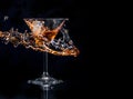 Cocktail splash in martini glass over black background with copyspace. Alcohol drink menu design Royalty Free Stock Photo