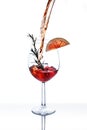 Cocktail splash in wine glass with citrus fruit slice, rosemary and ice isolated on white background. Italian aperol spritz