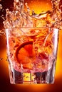 Cocktail splashing on orange background