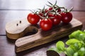 Cocktail tomatoes and basil on wooden board