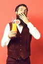 Cocktail in vintage suede leather waistcoat on red studio background. surprised handsome bearded man Royalty Free Stock Photo