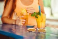 Cocktail in woman hand on the open terrace in bar during summer time