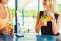 Cocktail in woman hand on the open terrace in bar during summer time