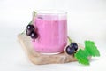 Cocktail of yogurt with black currant berries in glass on wooden board. Cocktail is decorated with bunches black currant berries Royalty Free Stock Photo