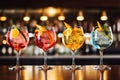 Cocktails on bar counter in pub. Alcoholic drinks, Five colorful gin tonic cocktails in wine glasses on the bar counter in pub or Royalty Free Stock Photo