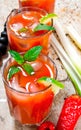 Cocktails made of tomatoes, vodka, ice, lime, pepper , salt and snack with celery and black olives on rustic background . Royalty Free Stock Photo