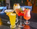 Cocktails on the table. Different coloured drinks in different glasses on dark wooden table Royalty Free Stock Photo