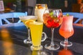 Cocktails on the table. Different coloured drinks in different glasses on dark wooden table Royalty Free Stock Photo